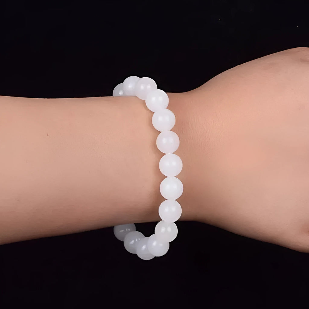 Hotan white jade goat fat round bead bracelet with 10mm Hetian jade beads on a neutral background