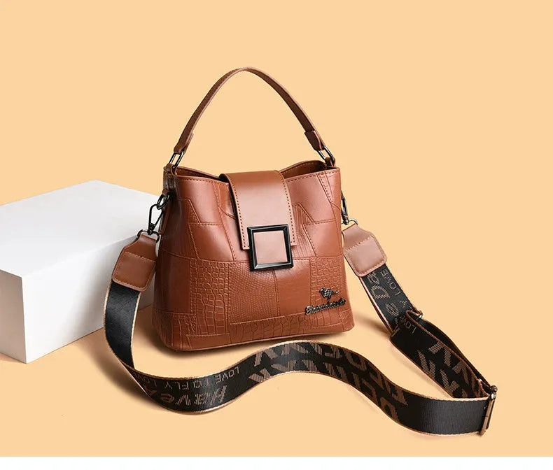 PU leather crossbody handbag with sewing line detail in brown, showing outer sandwich pocket and adjustable strap against neutral background