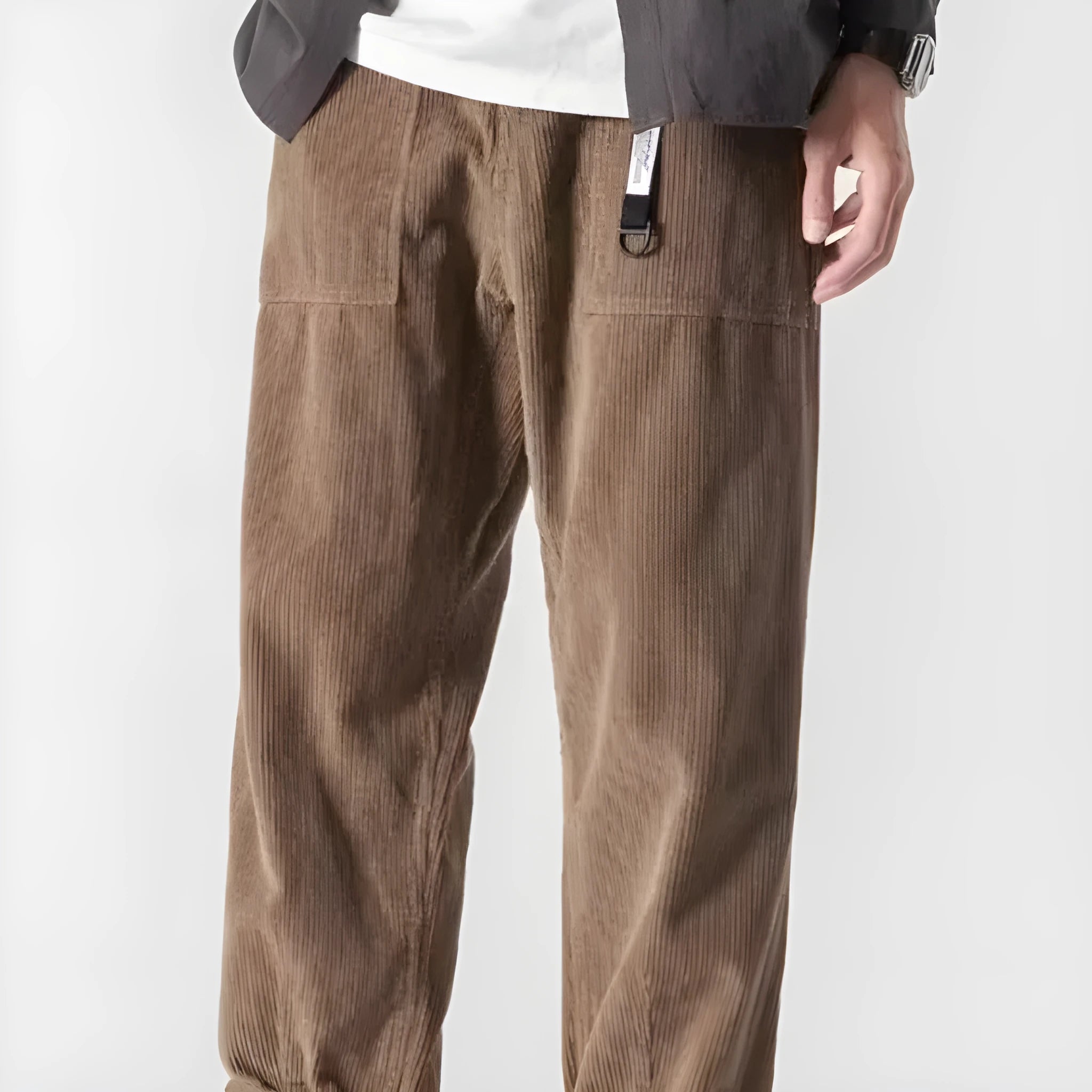 Man wearing loose straight leg casual trousers in dark grey, showing tapered fit and wide leg opening.