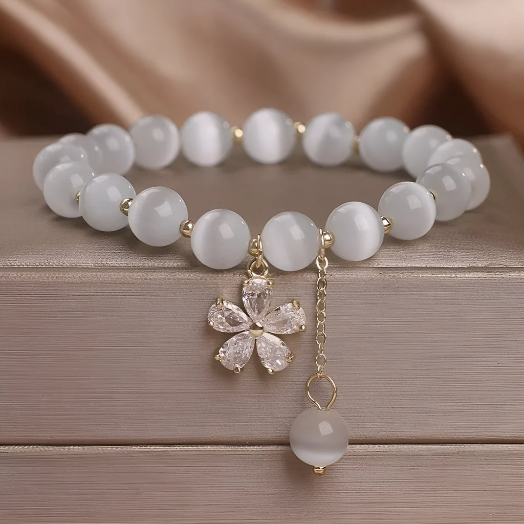 Single loop white cat's eye crystal bracelet with flower tassels and a morganite safety buckle pendant.