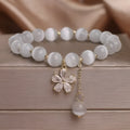 Single loop white cat's eye crystal bracelet with flower tassels and a morganite safety buckle pendant.