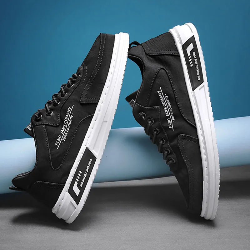 Men's green canvas lace-up sneakers with round toe, flat heel, and letter print side detail on a white background