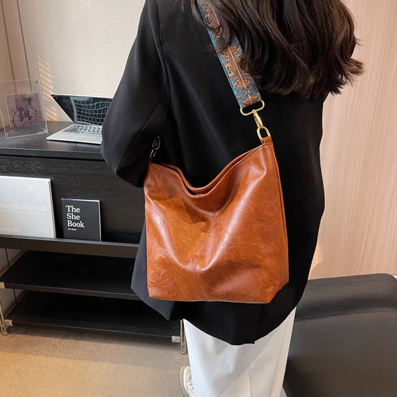 Retro bucket bag with wide shoulder strap, solid colour in beige, shown from front angle