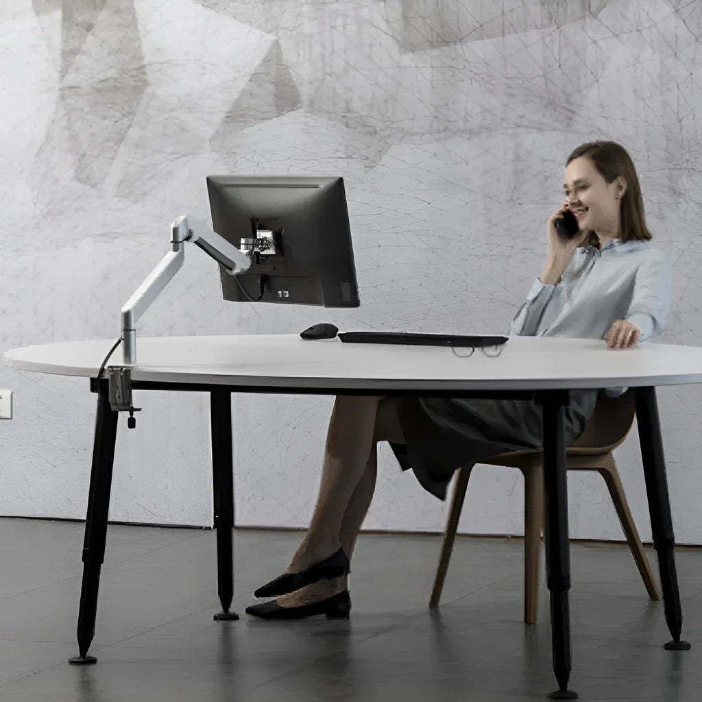 Silver aluminium alloy hover notebook stand on a desk holding a laptop.