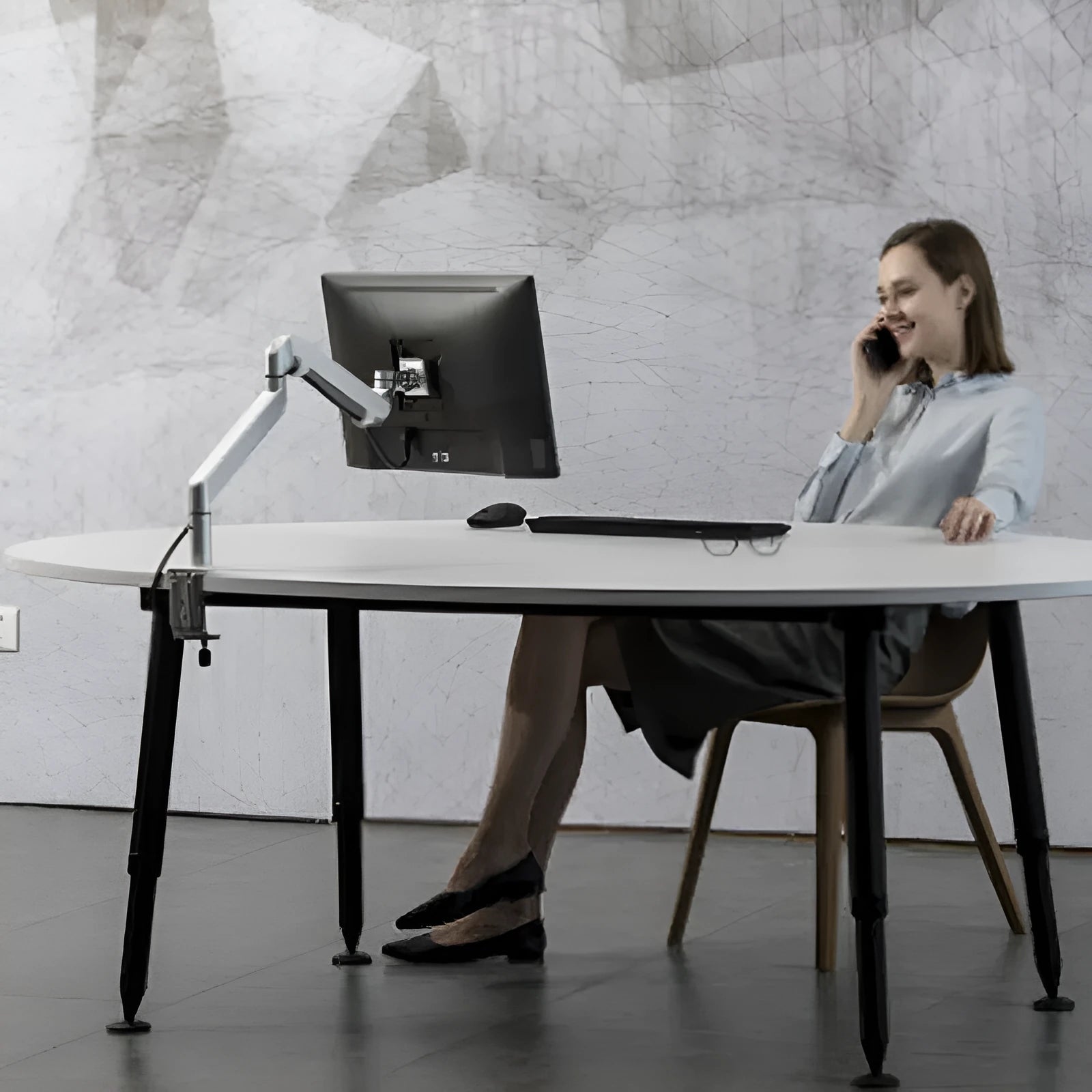 Silver aluminium alloy hover notebook stand on a desk holding a laptop.