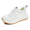 Women's beige low-top casual leather sports shoes with lace-up front and cross-strap detail on a white background