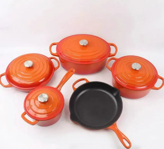 Cast iron enamel casserole set with frying pan and stew pot in light blue colour on a wooden table