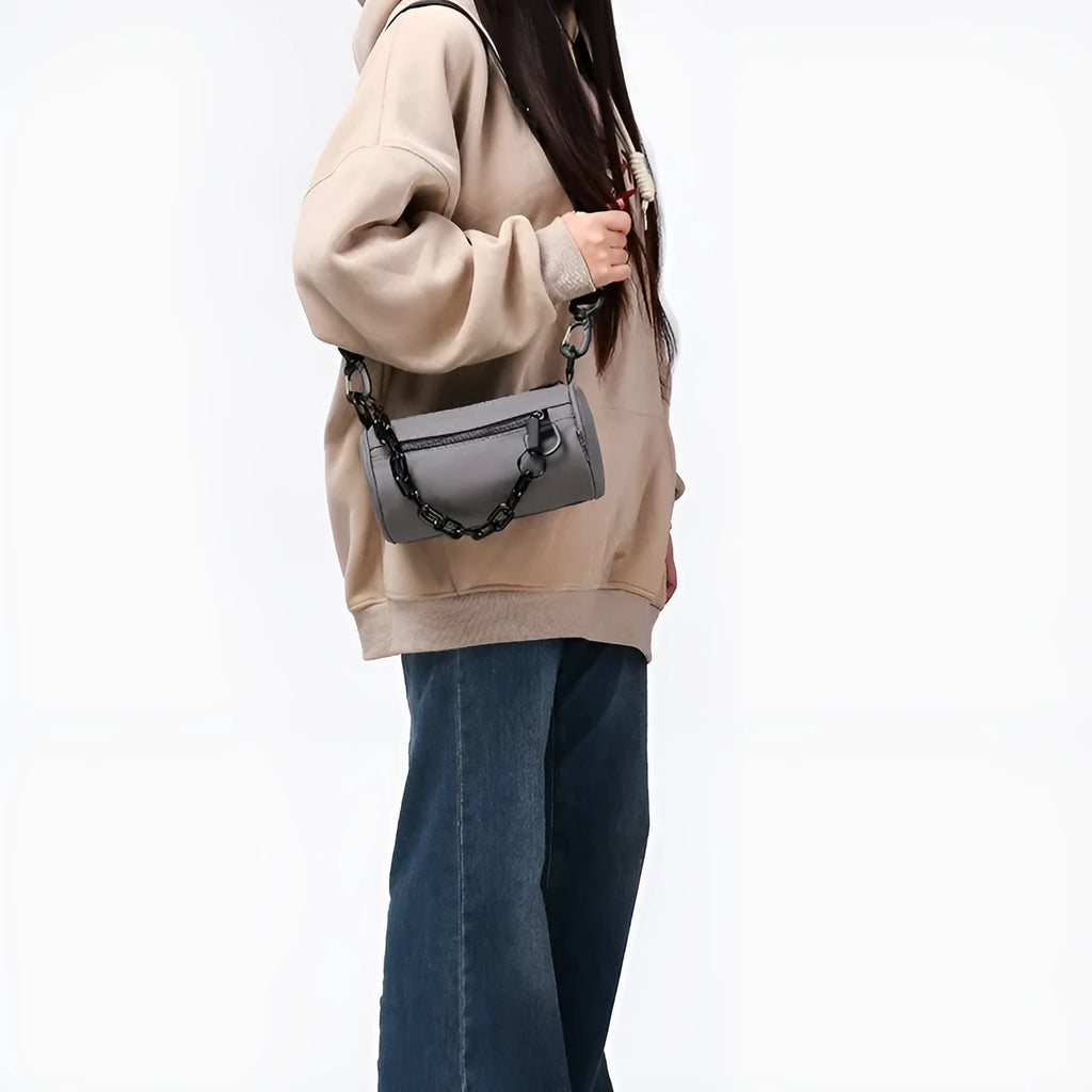 Black casual messenger bag with chain detail and crossbody strap made from Oxford cloth.
