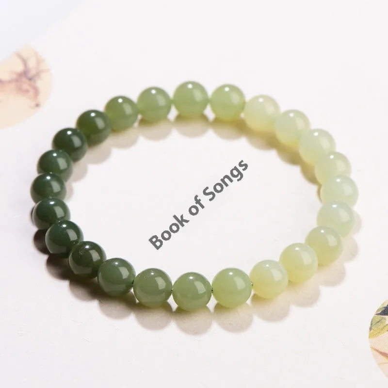 Natural clear water Hetian jade bracelet with round beads and barrel bead options on a wrist.