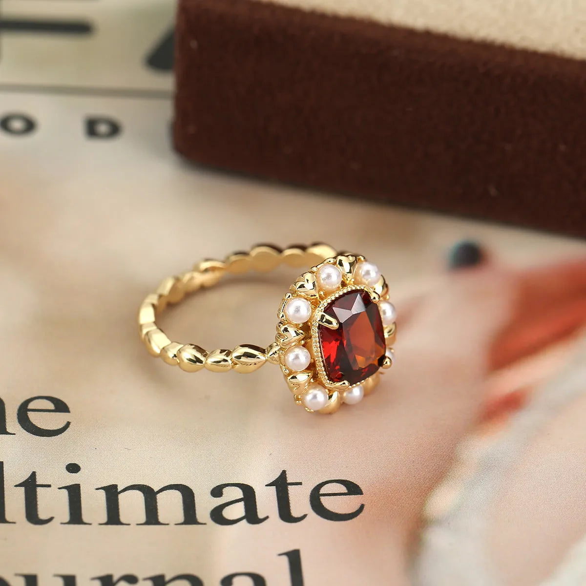 Gold electroplated ring with garnet red heart stone and geometric zircon setting.