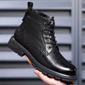 Black and brown leather Martin ankle boots with a rubber sole and visible stitching.