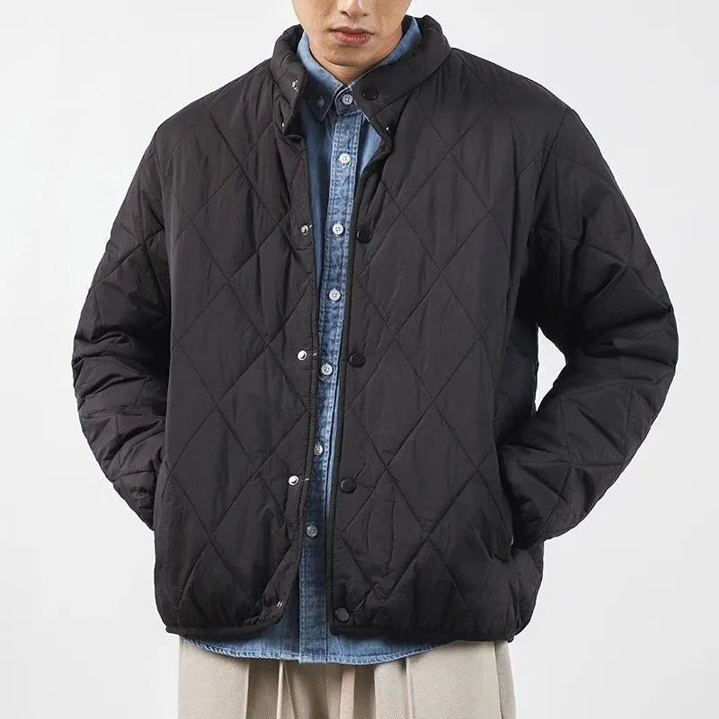 Men's black diamond lattice quilted winter jacket showing lengthened silhouette and loose fit