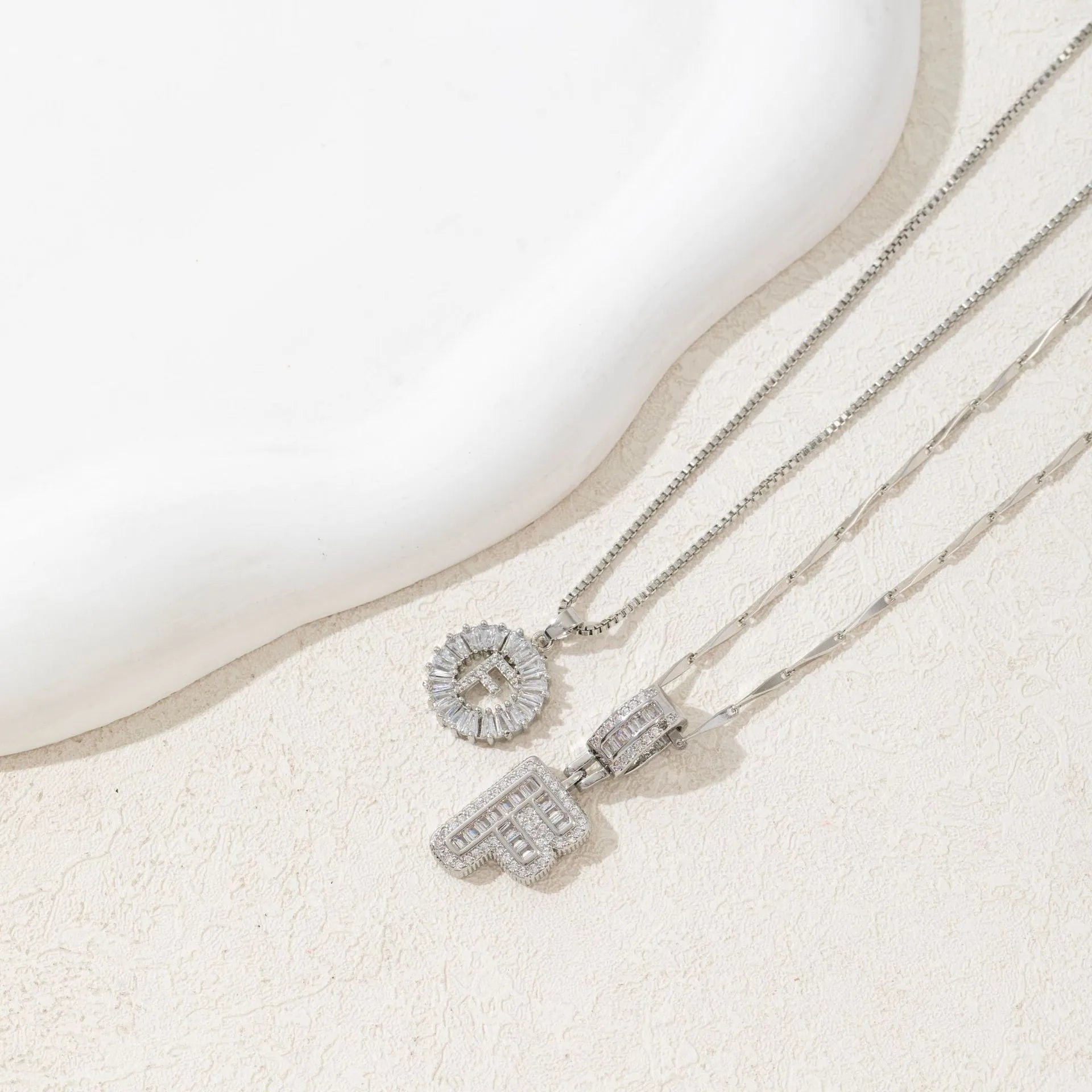 26 English letters copper-plated gold diamond initial pendant necklace with adjustable chain on display