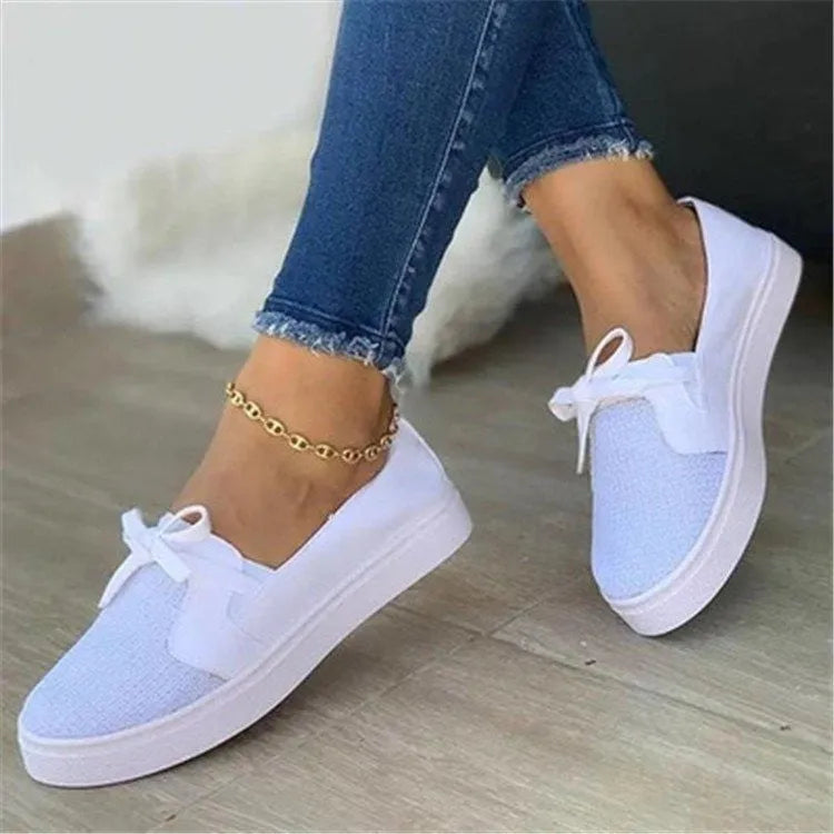 Women's low top flat shoes with cloth upper and shallow mouth cut, shown in white, red, blue, and black