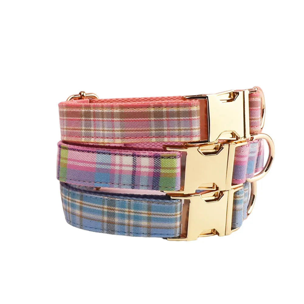 Plaid cloth dog collar and leash set with matching vest and decorative bow.