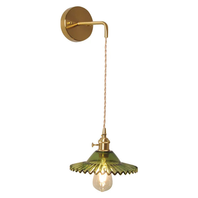 Retro brass-toned copper wall lamp with a white glass lotus shade mounted beside a bed.