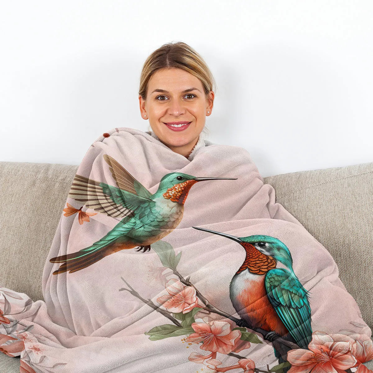 Pink hummingbird floral fleece throw blanket on sofa with floral print