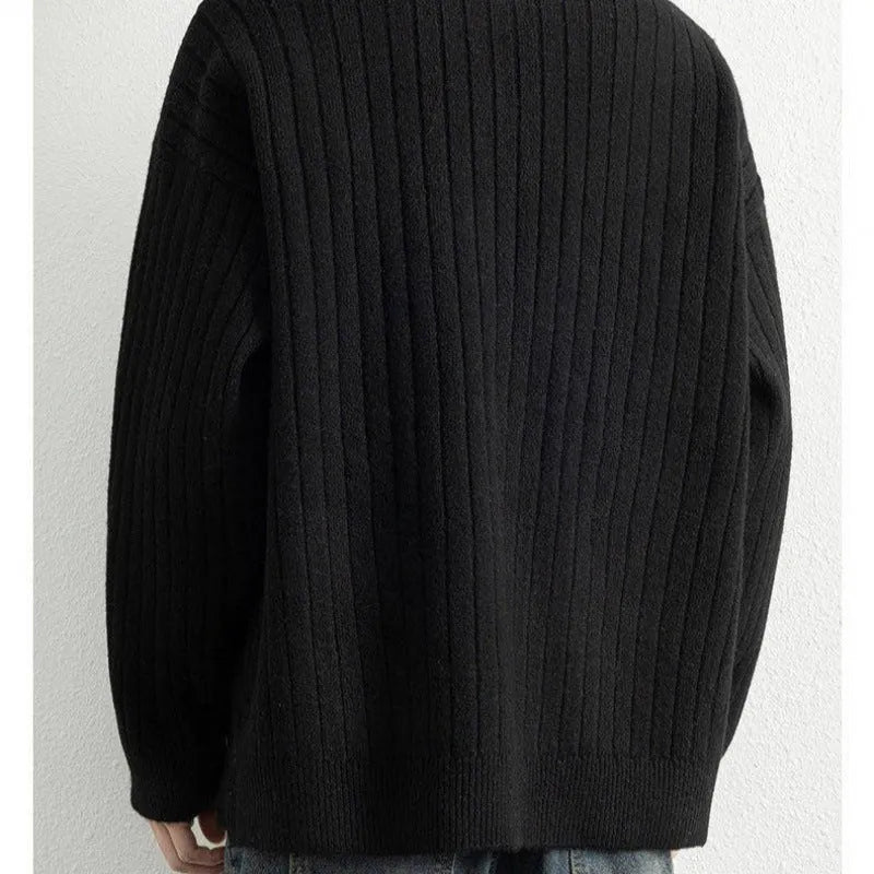Man wearing a grey half-zip loose fit knitted sweater pullover.