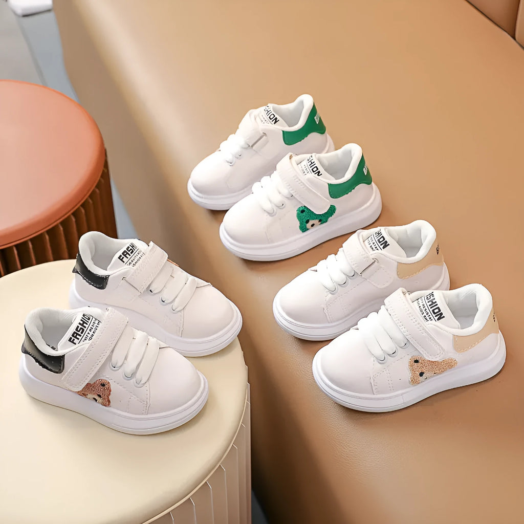 Children's black sports shoes with a cartoon bear design on the artificial leather upper and a rubber sole.