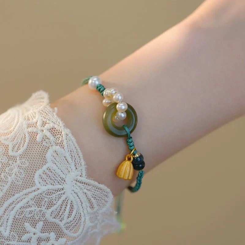 Hand-woven women's watch band with pearl details and a peace buckle in a retro style.