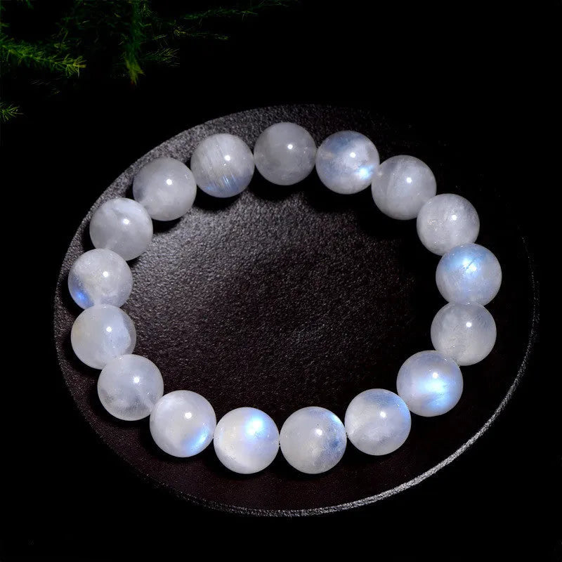Natural blue and white polished moonstone round bead bracelet on a white background.