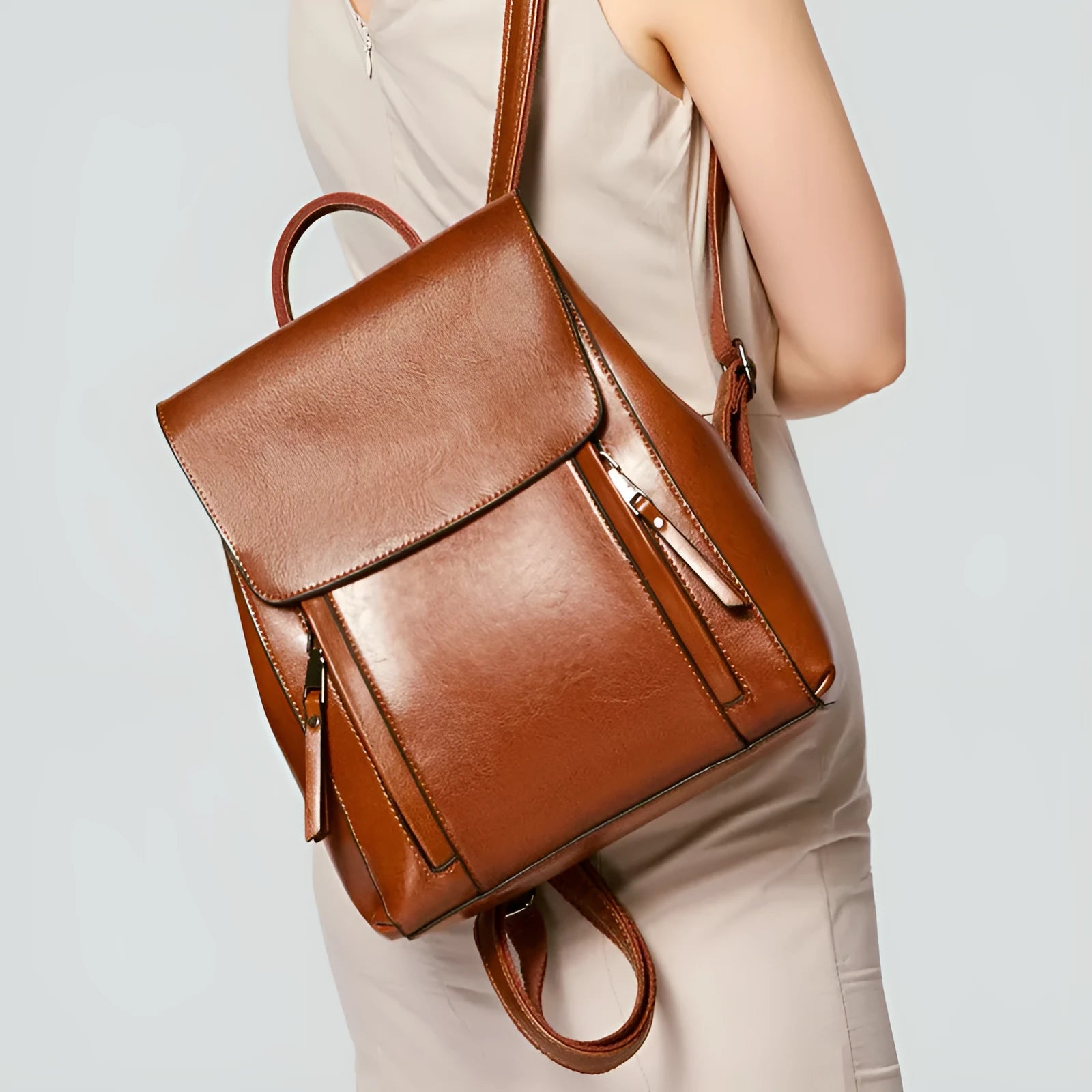 Women's black genuine cowhide leather backpack with stitching detail, shown open to reveal internal zipper and document pockets.