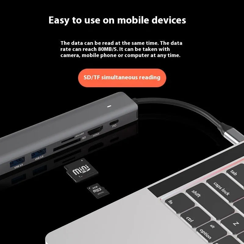 LQT-LH07 7-in-1 USB-C card reader and computer hub on a desk next to a laptop.
