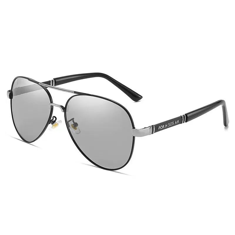 Men's gold metal frame polarised sunglasses with dragon and phoenix decoration and grey lenses on a table.