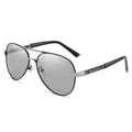 Men's gold metal frame polarised sunglasses with dragon and phoenix decoration and grey lenses on a table.