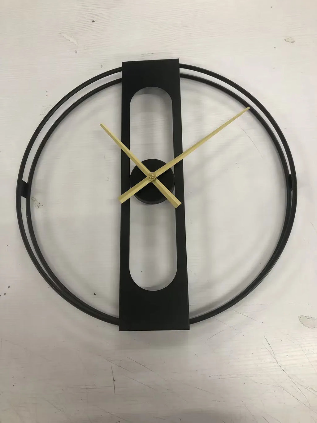 Round metal wall clock with 50cm diameter in black or gold finish on white wall