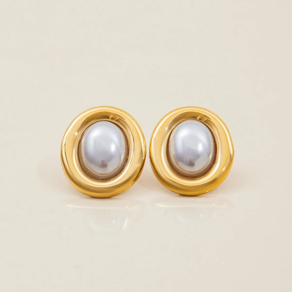 A pair of stainless steel stud earrings with a vintage pearl centre in a silver-tone finish.