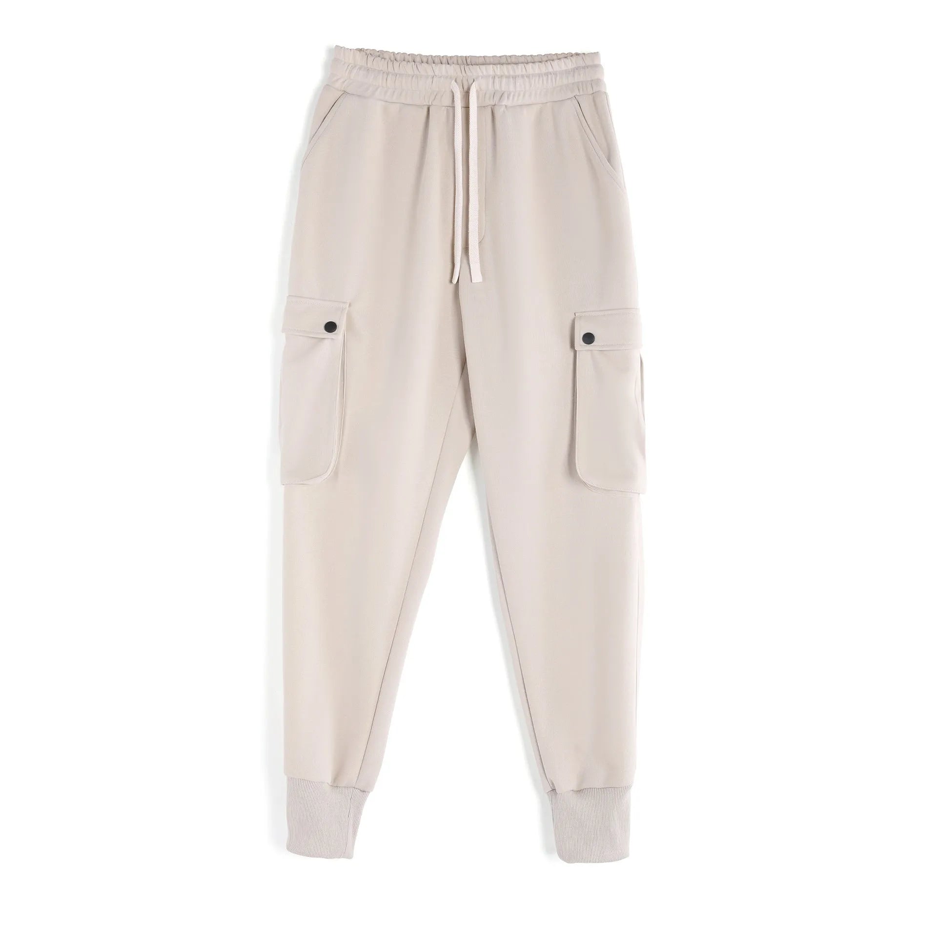 Man wearing loose-fit light grey cotton trousers with ankle ties and multiple pockets, suited for casual sports.