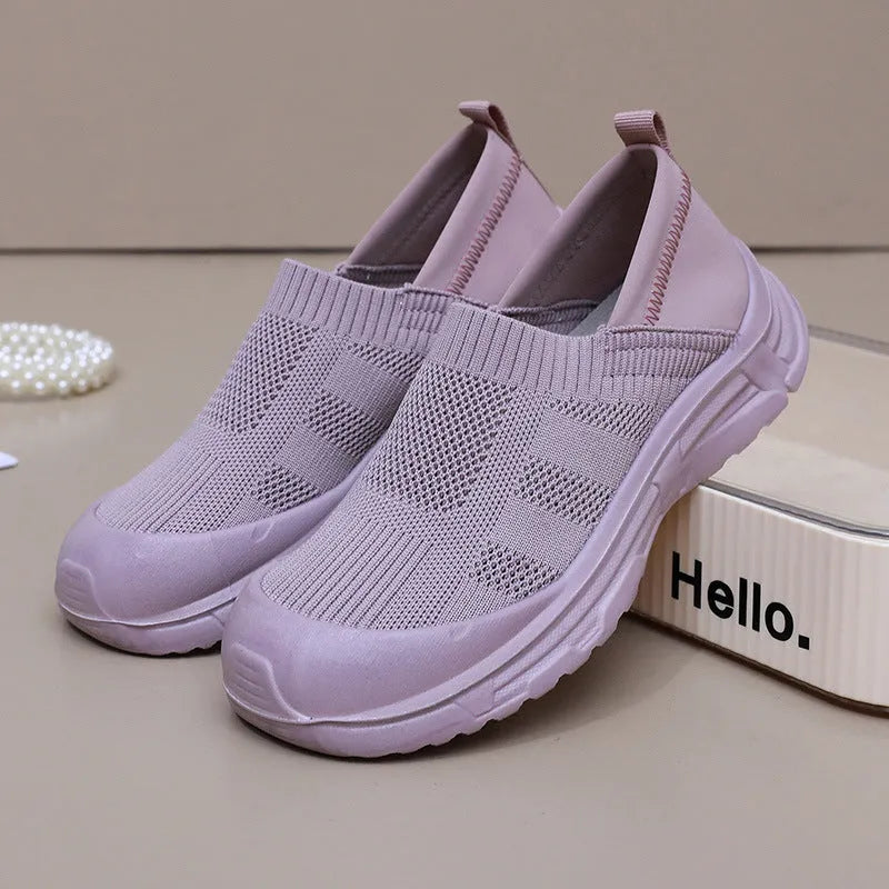Women's black slip-on shoe with a cloth upper and soft PVC sole on a white background