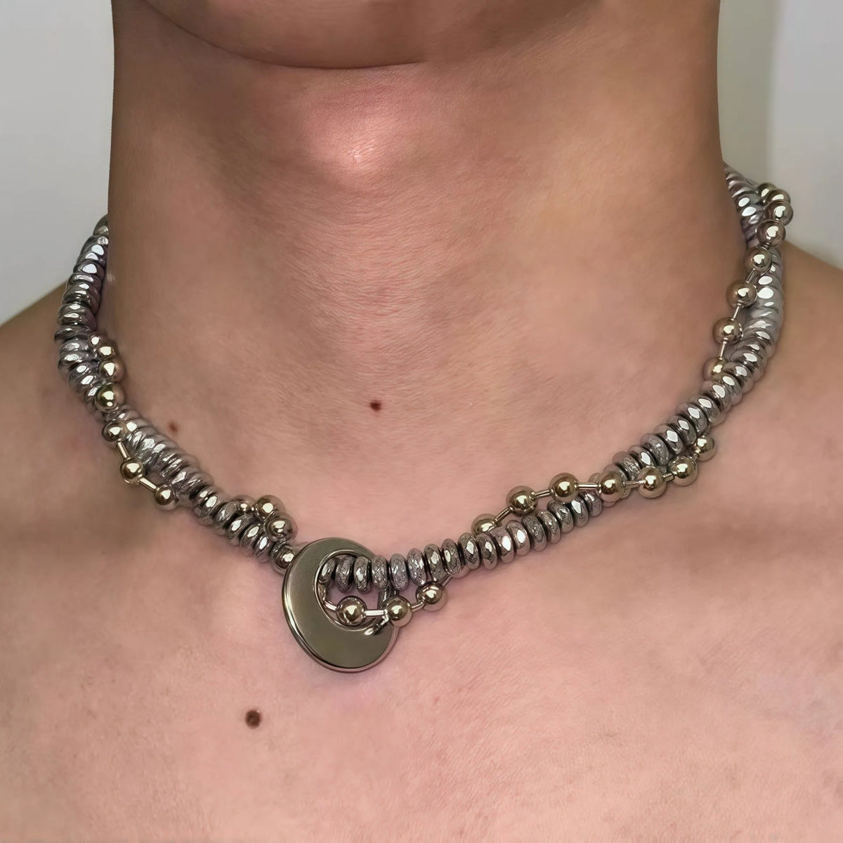 Silvery hand-woven titanium steel hip hop necklace with winding heavy industry chain texture on white background