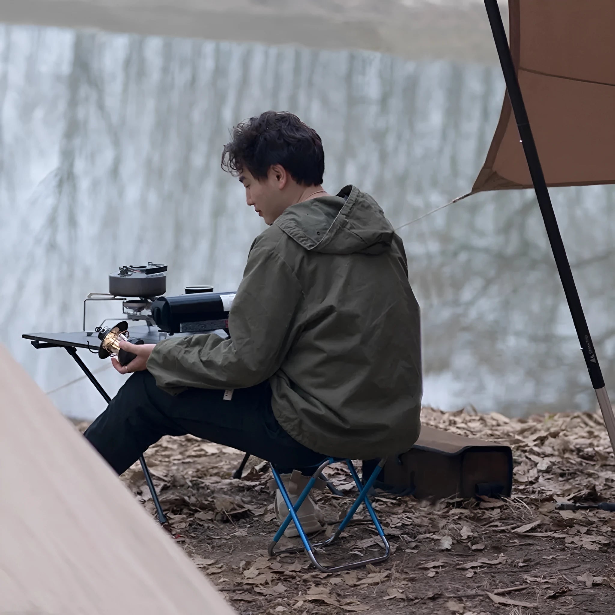 Black aluminium alloy folding stool in a portable design for outdoor camping and fishing.