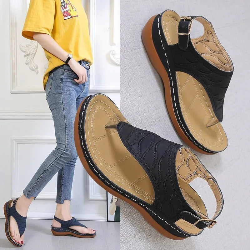 Women's casual wedge heel flip flop sandal in black with adjustable buckle strap.