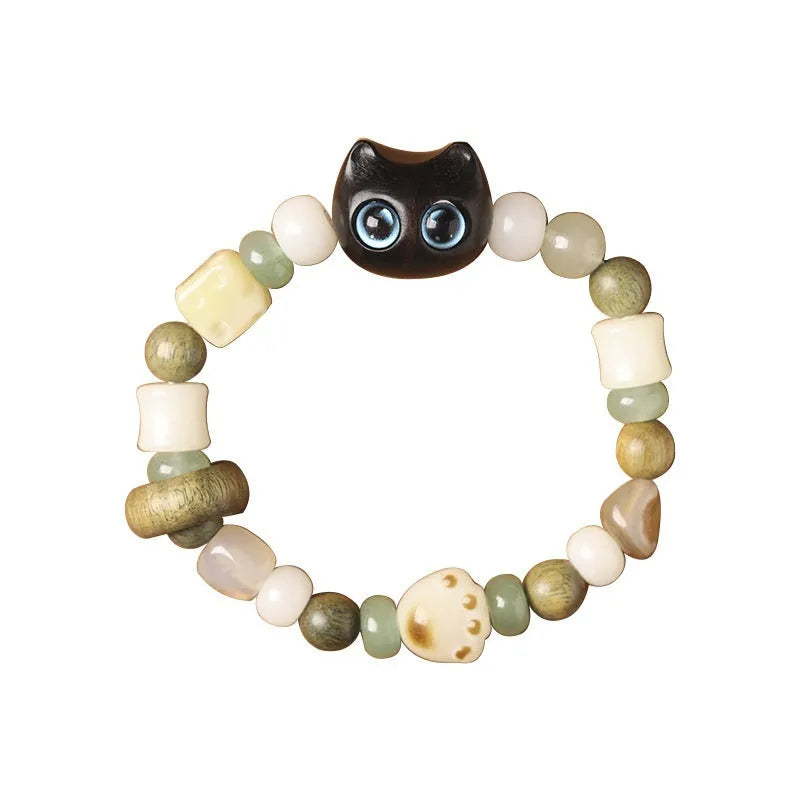 Beaded bracelet with a cube sugar cat's paw charm in guajacwood or ebony, featuring jade beads and a choice of yellow or blue eyes.