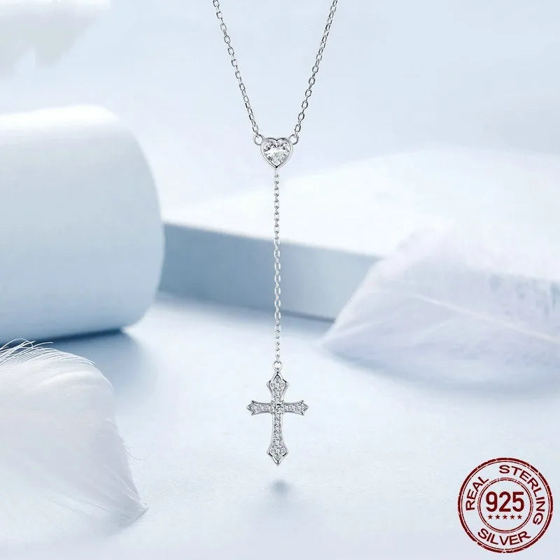 Simple silver love cross pendant necklace with O-ring chain on a V-neck.