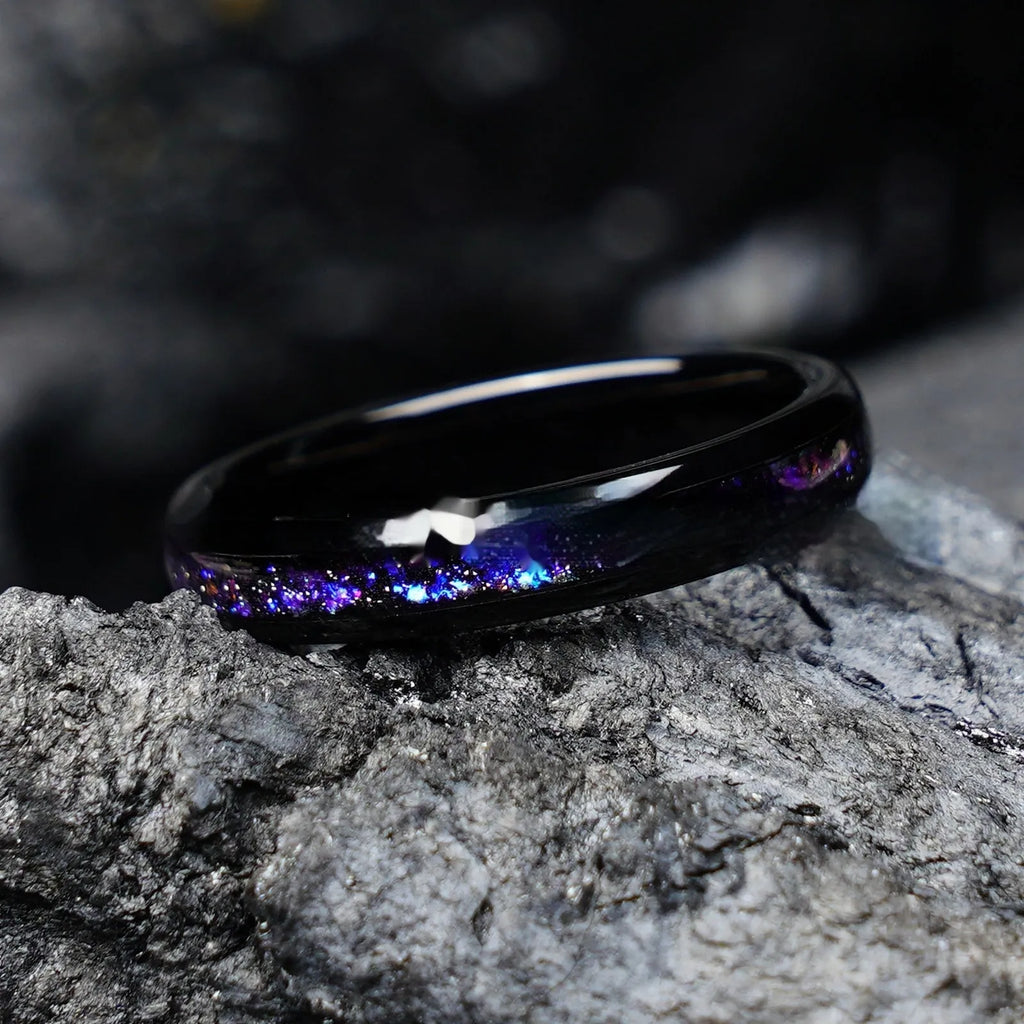 Galaxy tungsten ring with electroplated black finish and coloured inlay on a plain background