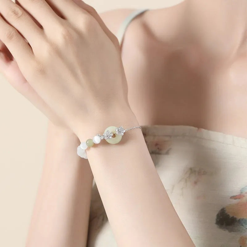 Women's pure silver safety buckle bracelet with peach blossom design in gold colour.
