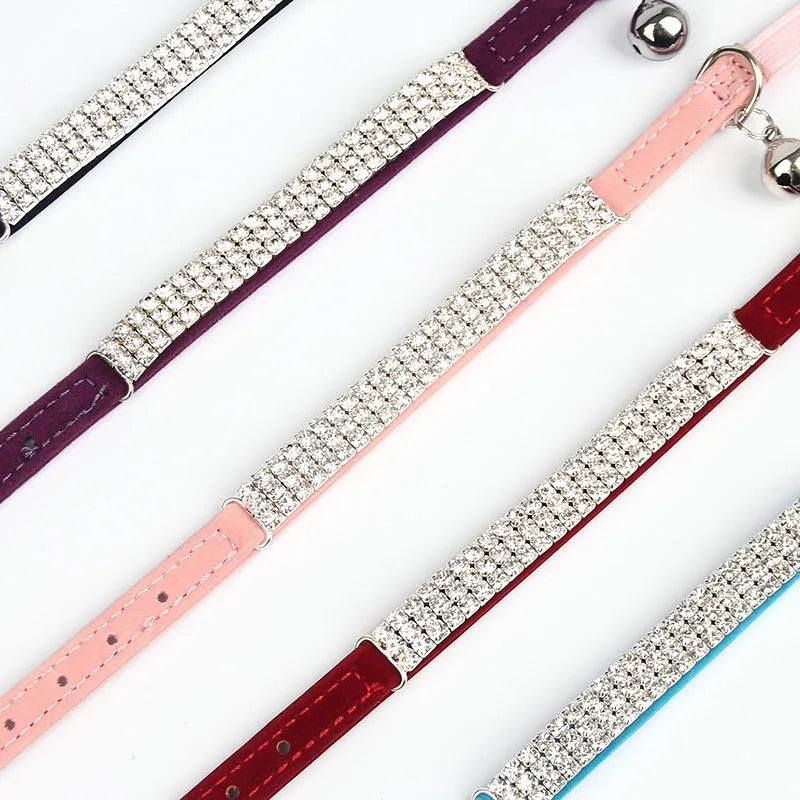 Red velvet adjustable cat collar on a table, showing buckle and 1cm width, length adjustable from 20 to 30 centimetres.