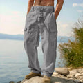 Man wearing loose grey cotton wide-leg casual trousers with an elasticated mid-waist.