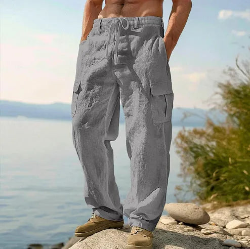 Man wearing loose grey cotton wide-leg casual trousers with an elasticated mid-waist.