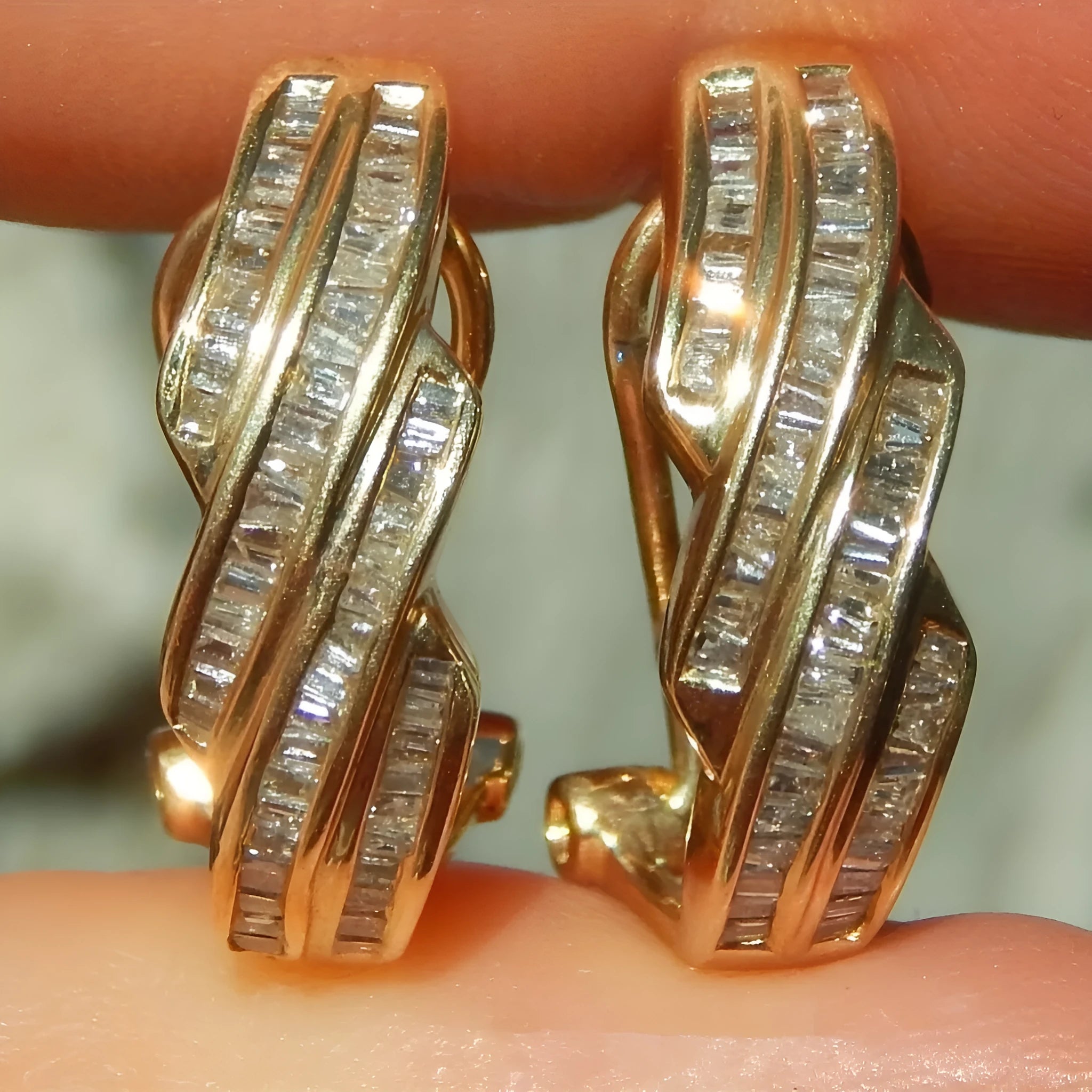 A pair of gold geometric earrings with a round copper design.