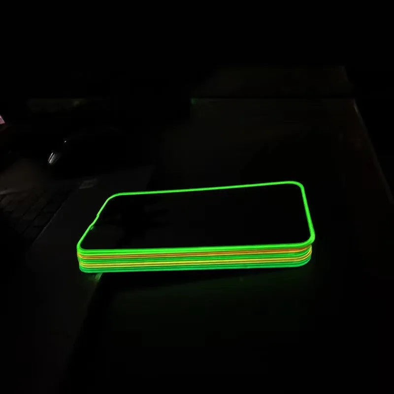Fluorescent pink luminous tempered glass screen protector applied on an iPhone 13, glowing softly in a dark setting.