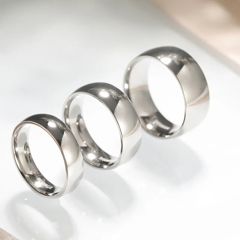 A simple silver-coloured titanium steel ring showing three width options: slim 2mm, standard 4mm, and wider 6mm band.