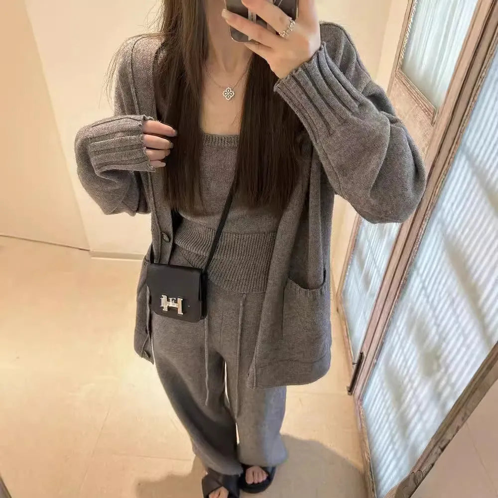 Women's light brown knit cardigan, vest, and loose trousers three-piece set laid flat.