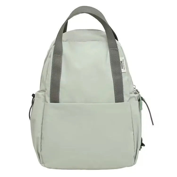 Solid colour nylon backpack in blue with curved straps and a lock, shown in a travel setting.