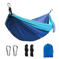 Blue parachute nylon camping hammock hung between two trees, showing its full 270cm length and 140cm width.
