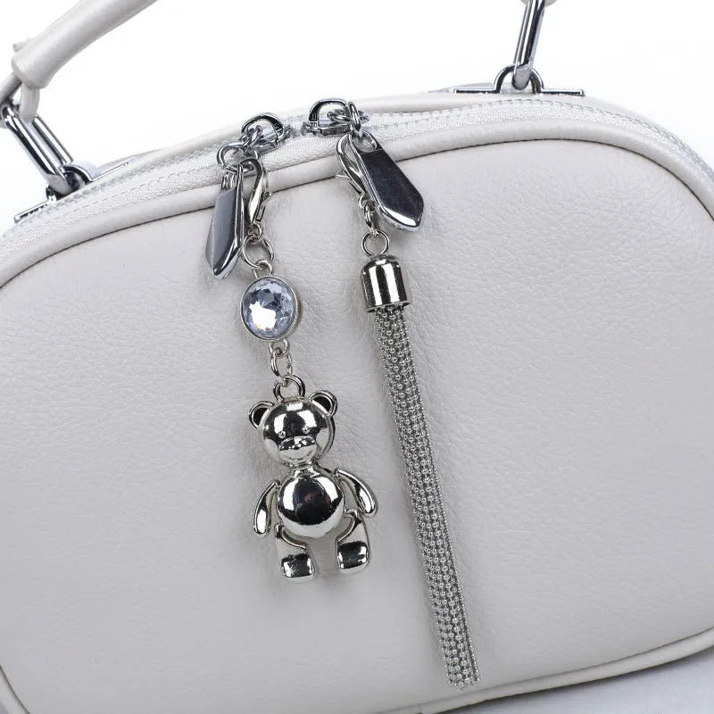 Oval-shaped women's small square bag in soft PU leather with double strap, shown in multiple colours.